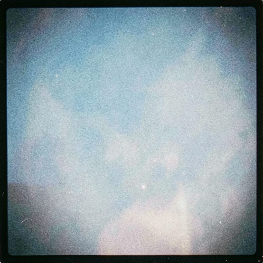 An analog film image in soft blush and ivory tones, dreamy and atmospheric with fine grain.